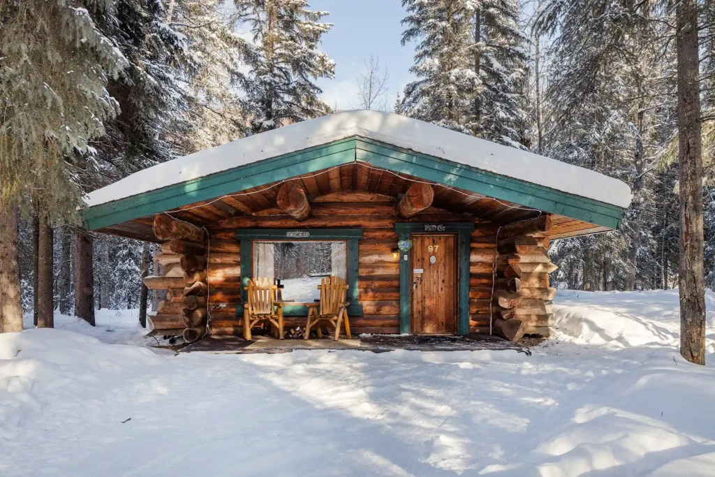 Cozy log cabin covered in snow at Chena Hot Springs Resort in winter