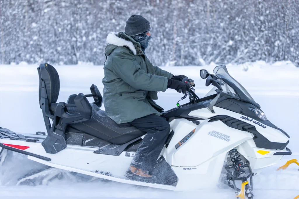 Side view of a rider on an electric snowmobile trail tour in Fairbanks, Alaska